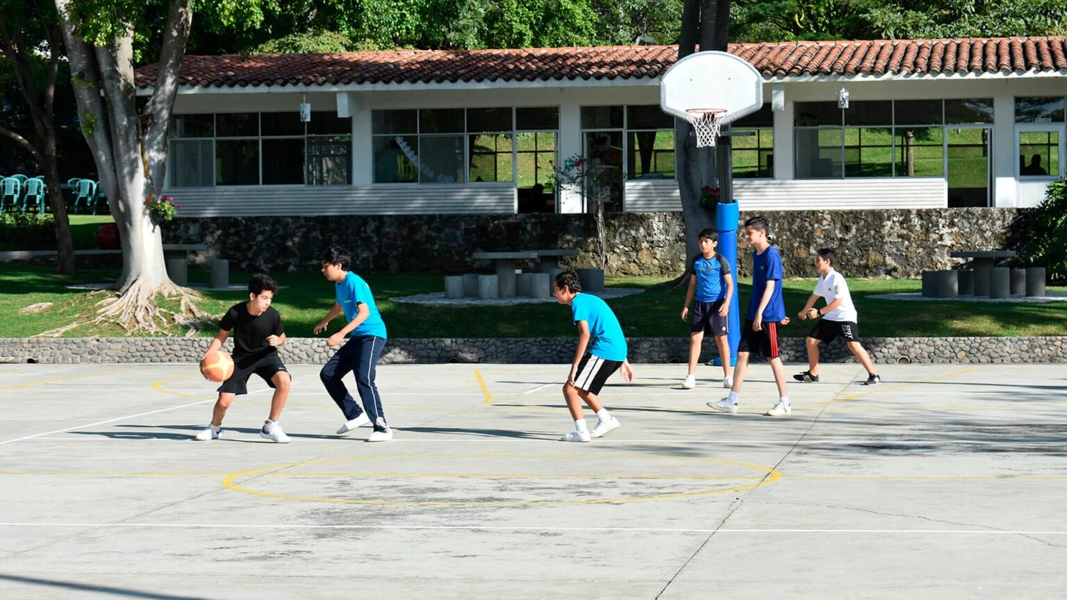 Alumnos jugando baloncesto entre los jardines del CEC
